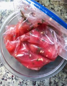 watermelon cubes marinating in rum a plastic bag in a bowl