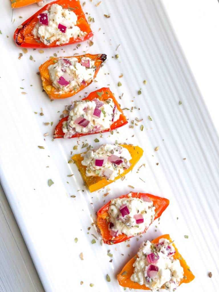 These roasted baby peppers stuffed with feta are a delicious and easy veggie appetizer for any party! I like to make them ahead and serve them cold for a fun finger food and simple crowd pleaser! Bite size and quick to make!