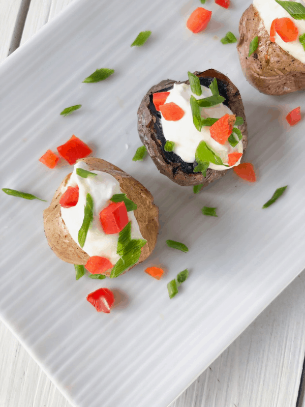 Mini baked potatoes with sour cream and cheese in the middle