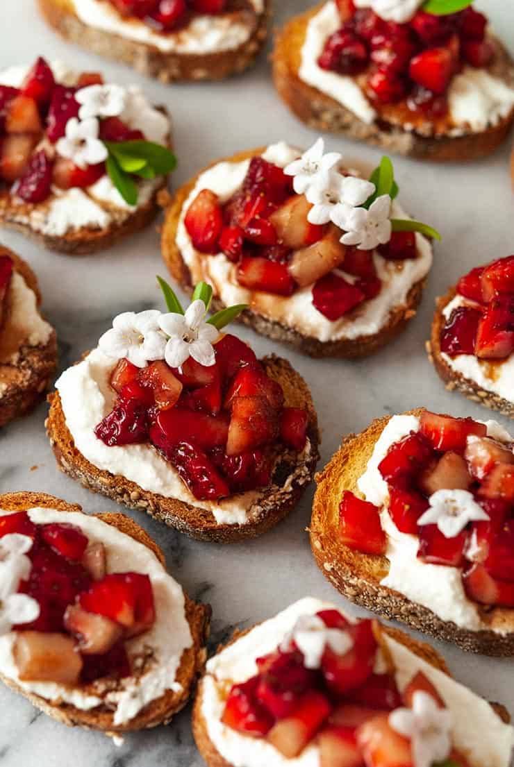 crostini with balsamic strawberries and ricotta on table. 