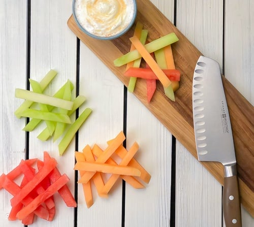 fruit fries cut into sticks on cutting board with knife
