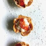 strawberry phyllo cups with cream cheese filling on a white plate