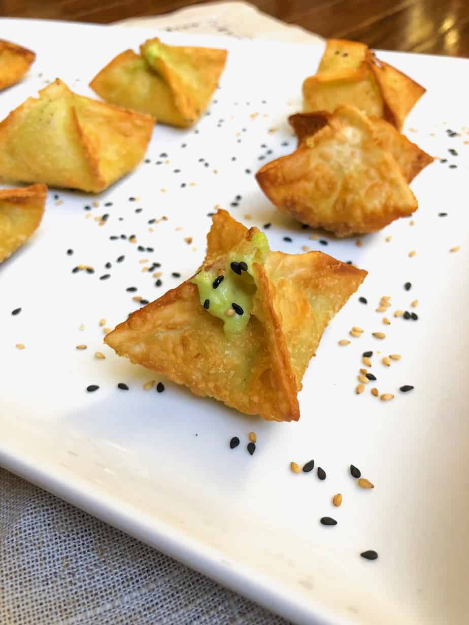 Avocado stuffed wonton appetizer on white plate.