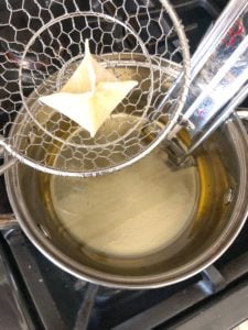 Frying avocado cream cheese wontons.