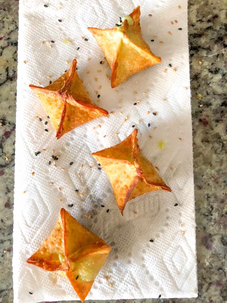 Fried avocado wontons on paper towel.