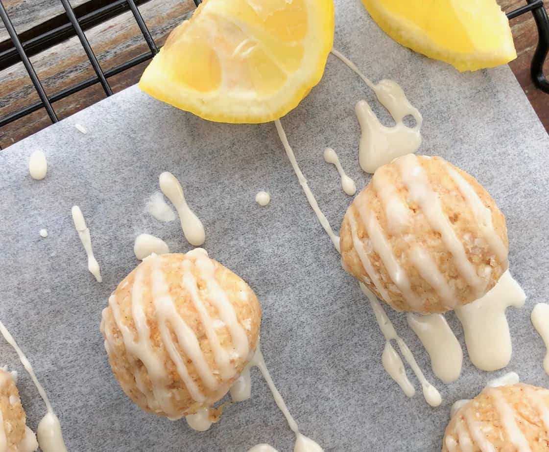 lemon cream cheese truffles with lemon drizzle on parchment paper.