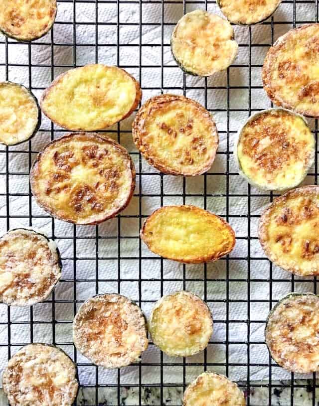 pan fried zucchini chips on a wire rack.