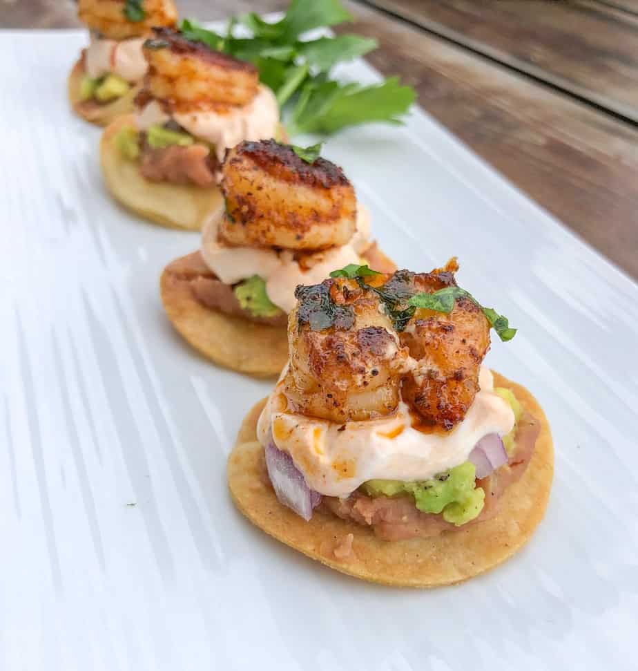 Mini shrimp tostadas bites baked on a plate.