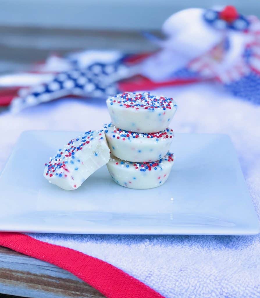 vanilla fudge bites without condensed milk stacked on a plate with red white and blue sprinkles