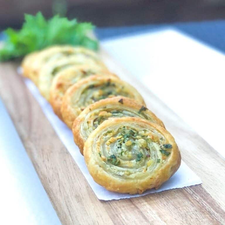 puff pastry pinwheels stacked against each other on board