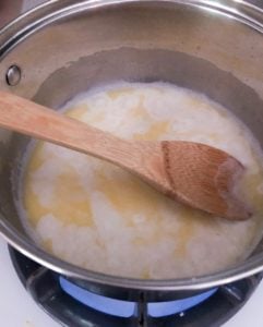 Boiling mixture in a pan with wooden spoon.