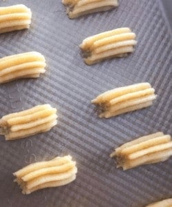Piped churro in baking sheet.