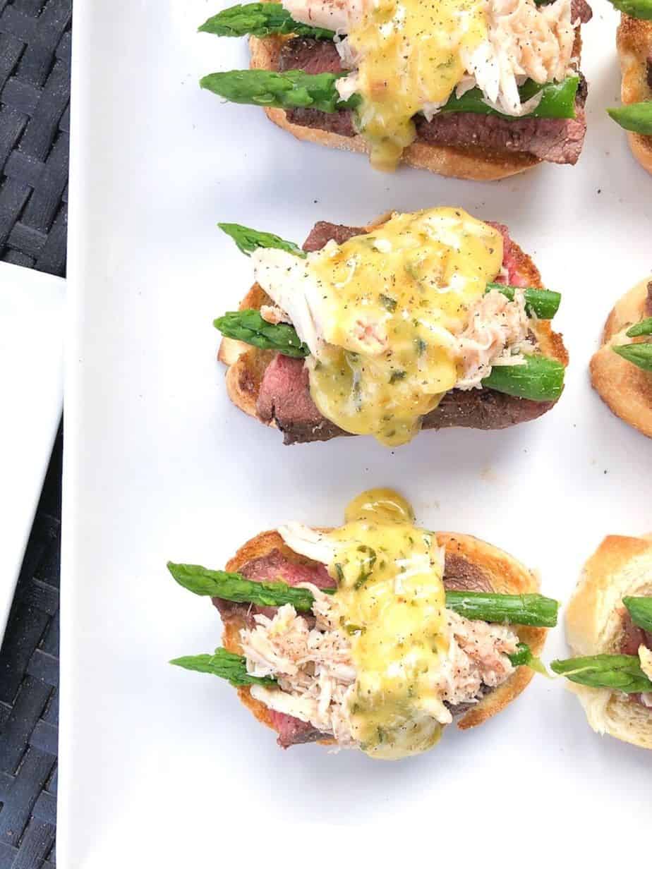 steak crab and asparagus crostini appetizer on a plate.