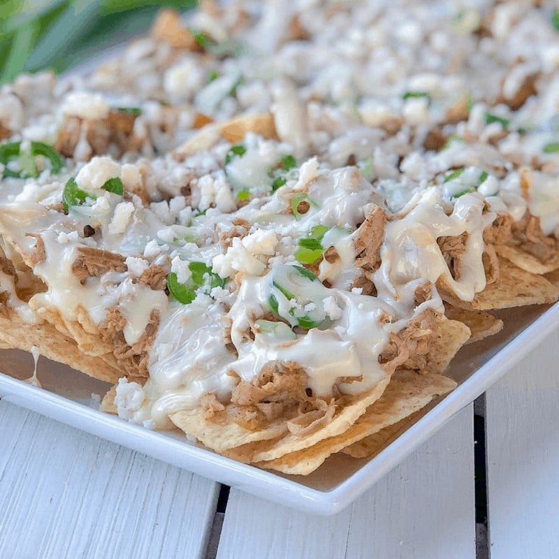 nacho chips topped with pulled pork and melted cheese.