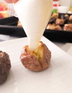 Adding cream to mini potato.
