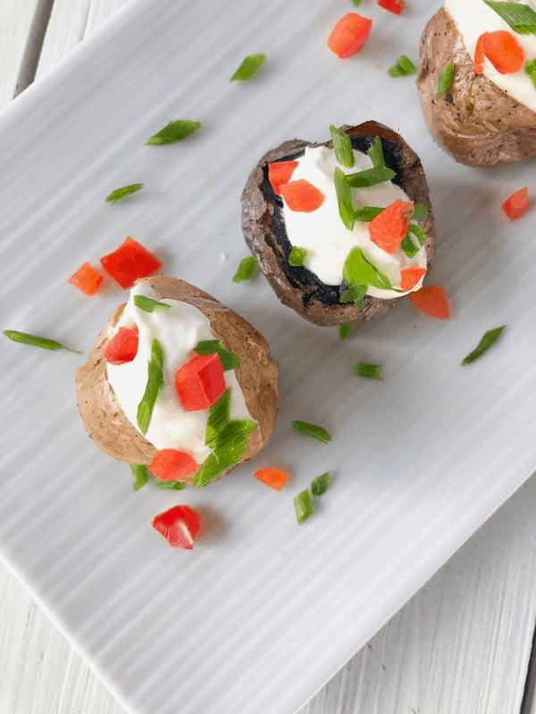 Overhead shot of mini baked potatoes with sour cream.