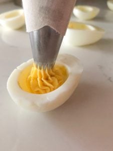 Filling the egg using piping bag.