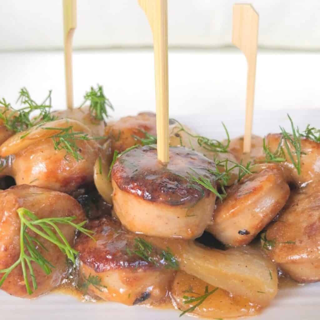 Chicken apple sausage skewered on a plate.