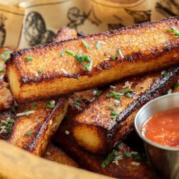 Polenta fries in a basket with marinara sauce.