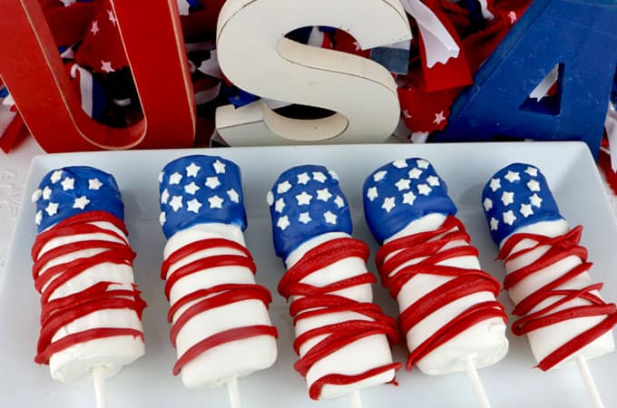 Red white and blue marshmallow pops on a plate.