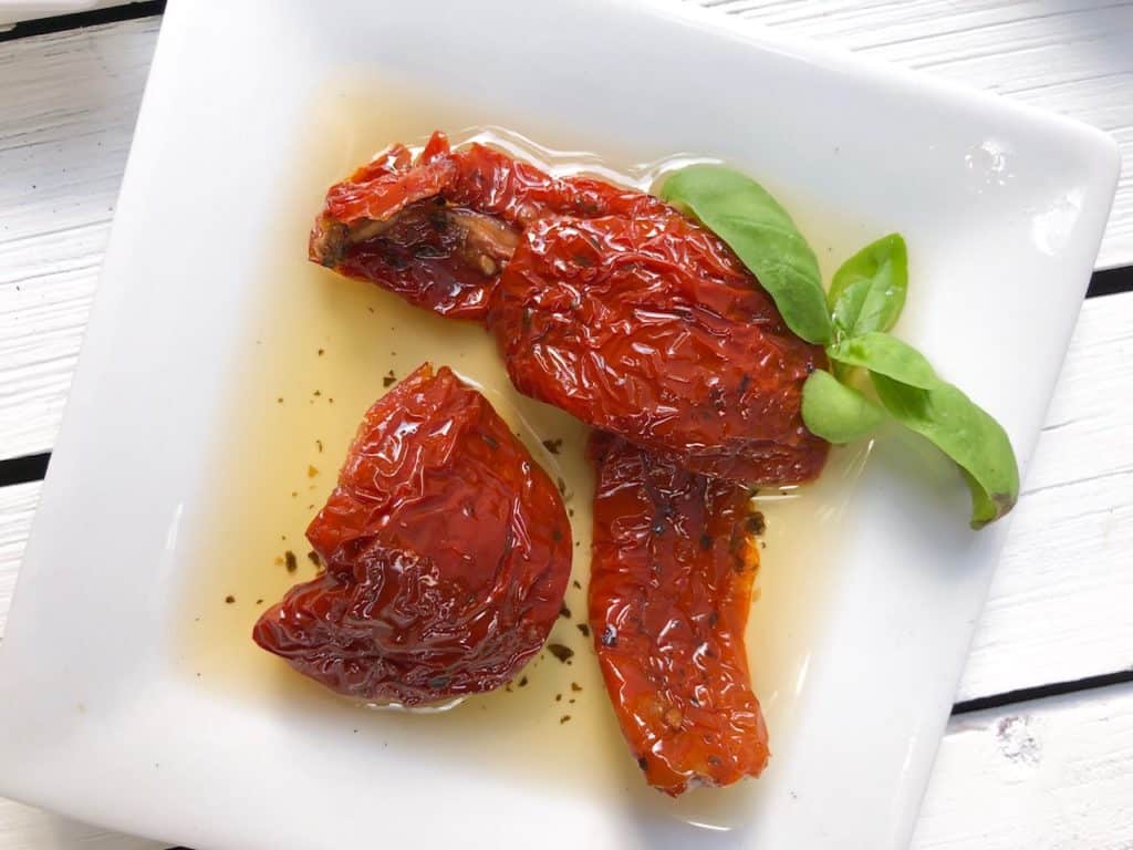 Sun dried tomatoes on a white plate.