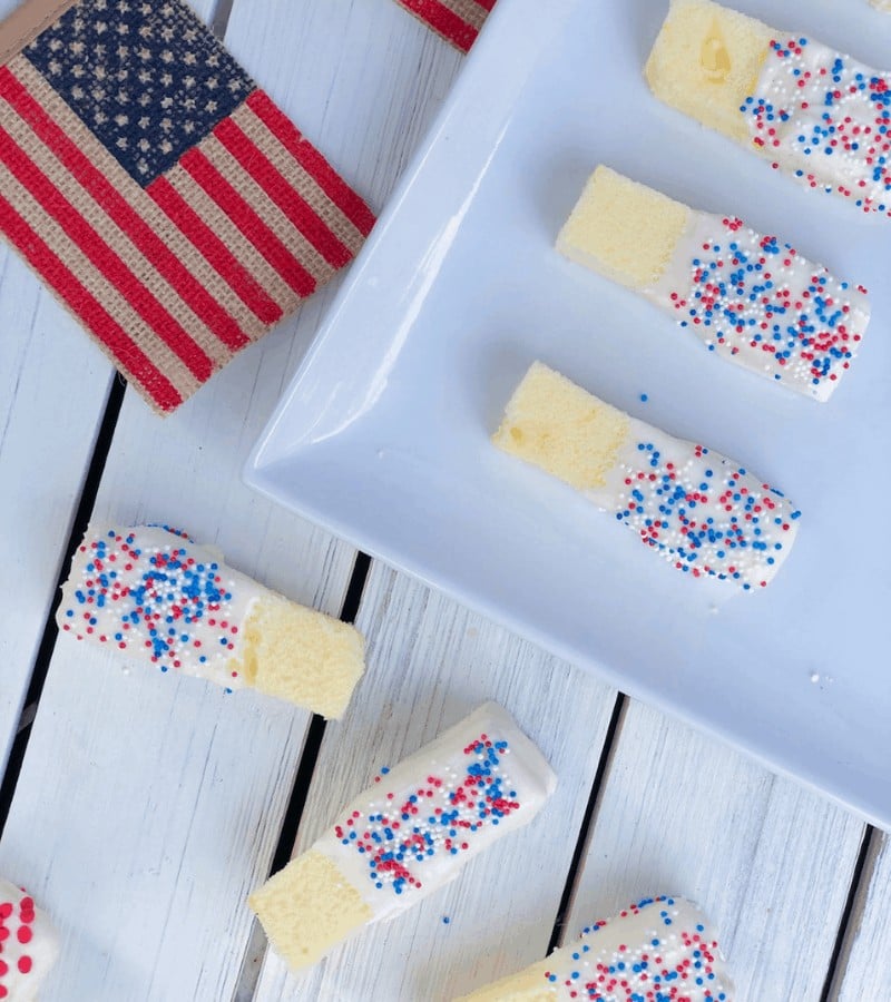 Fourth of July cake sticks dipped in white chocolate with sprinkles.