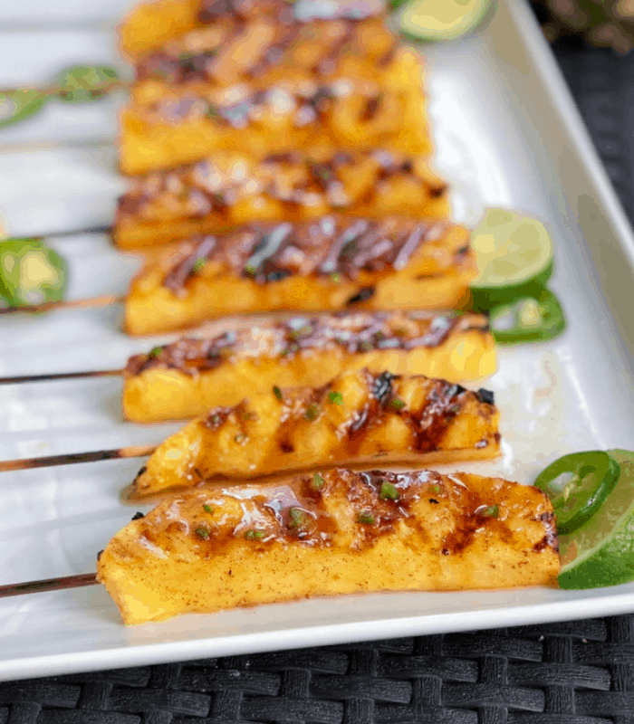 Grilled pineapple with cinnamon on a plate.