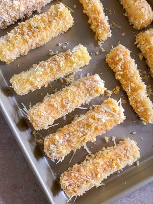 Eggplant fries on a baking sheet before being baked.