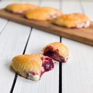 sweet empanadas with cherry filling on white board cut open
