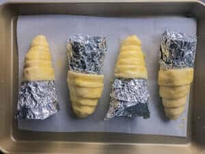 Pizza cones in a baking sheet.