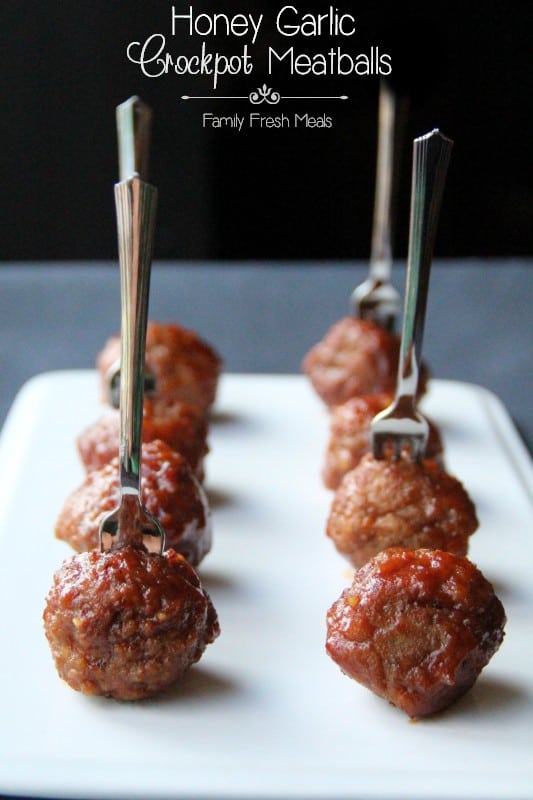 Meatballs skewered with a fork on a plate.