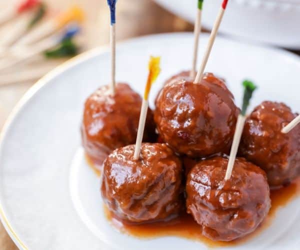 Skewered meatballs with sauce.