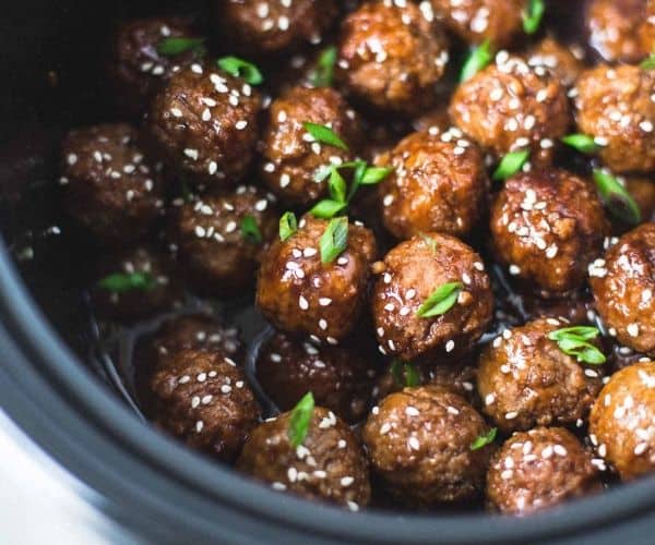 Turkey meatballs in a crock pot with sesame seeds.