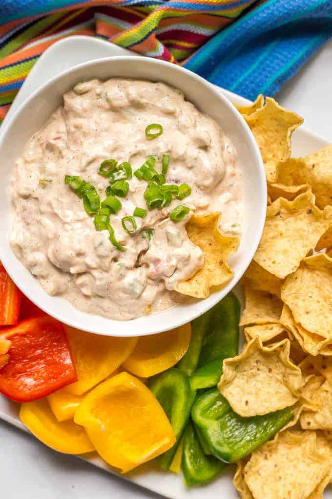 Cheese dip with cold chili and chips on the side.