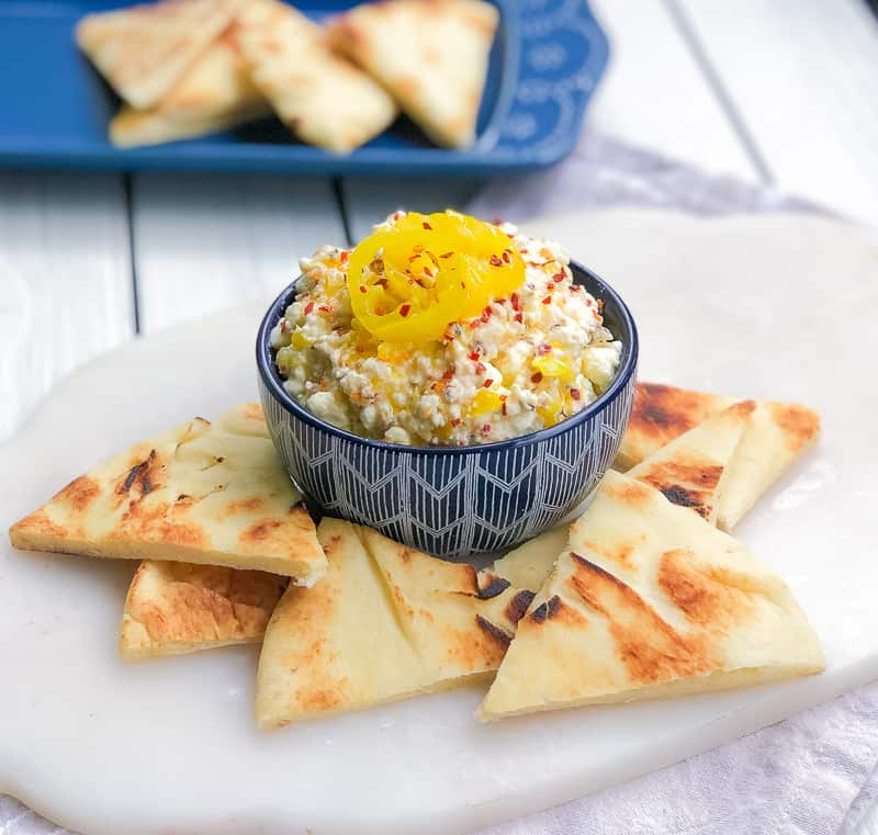 Feta cheese dip surrounded by pita triangles.