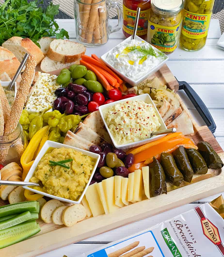 Large Greek meze board with dips, spreads, veggies and bread.