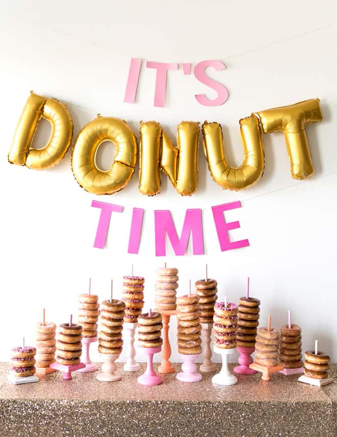 donut bar with donuts stacked and sign.