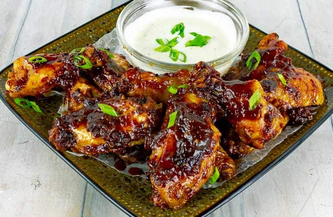 baked chicken wings appetizer smothers in bbq sauce on a plate