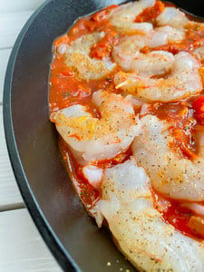shrimp in a cast iron skillet with tomato sauce