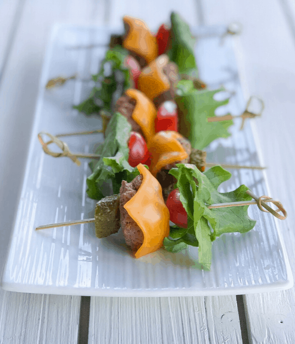 burger skewers appetizer on a long plate with melted cheese