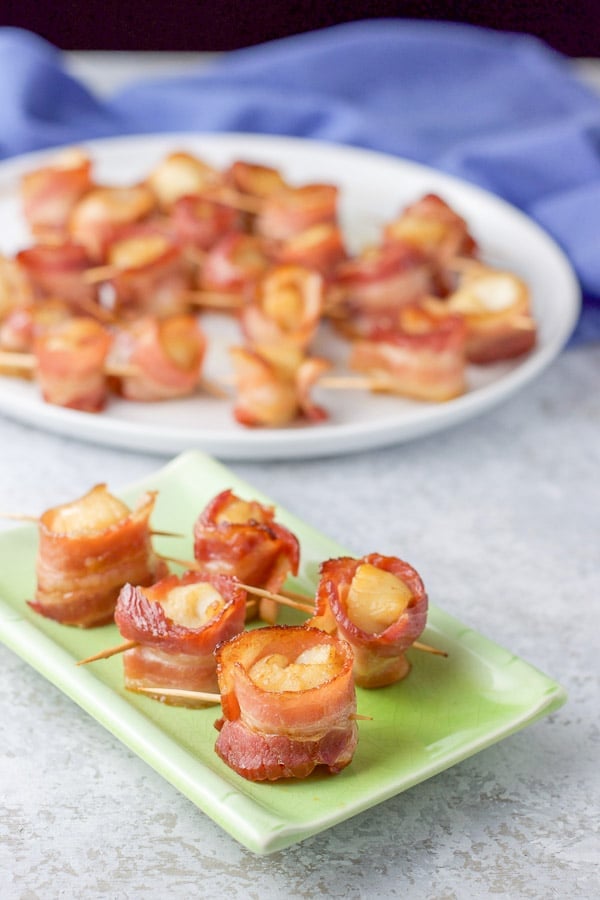 bacon wrapped scallops appetizer skewered on a plate