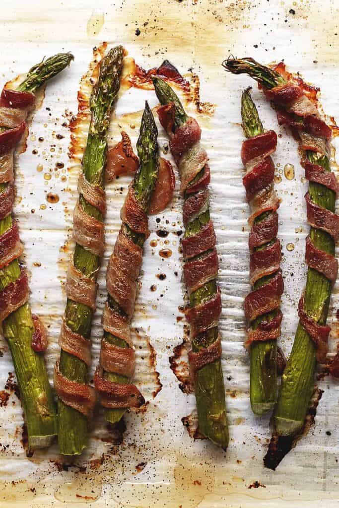 bacon wrapped asparagus appetizer on a baking sheet