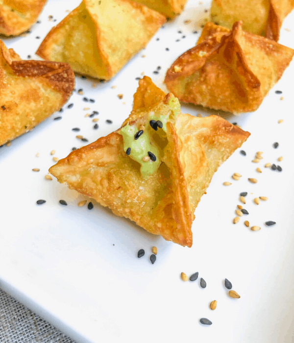 Stuffed avocado wonton wrappers appetizer with sesame seeds on top