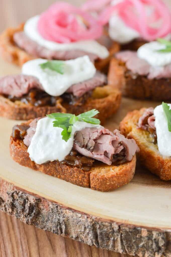 Roast Beef Crostini Hors d'oeuvres on a wooden plank