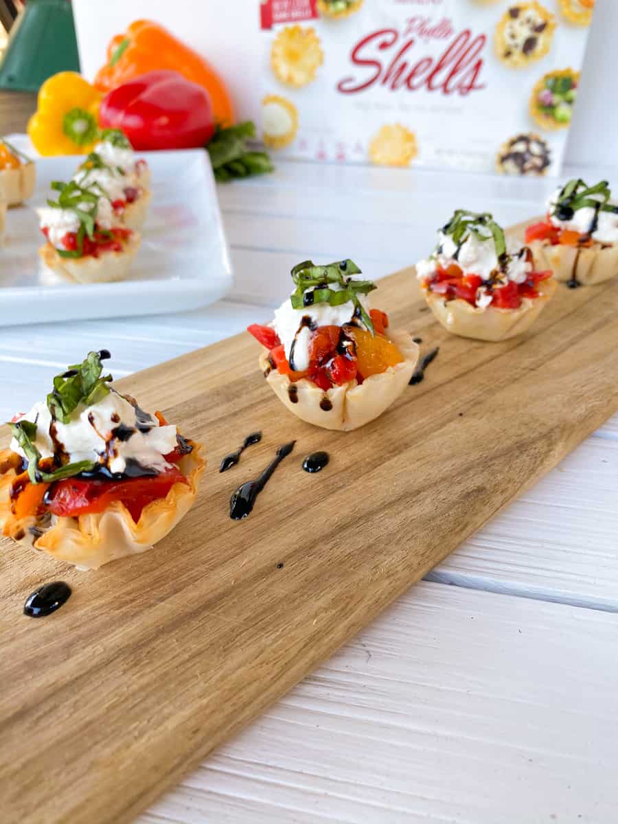 Phyllo cups finger food stuffed with peppers and burrata cheese.