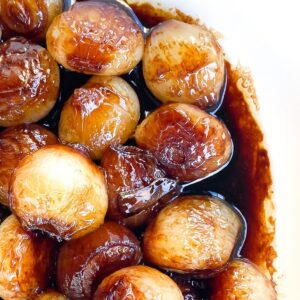 caramelized pearl onions in a bowl with balsamic glaze.