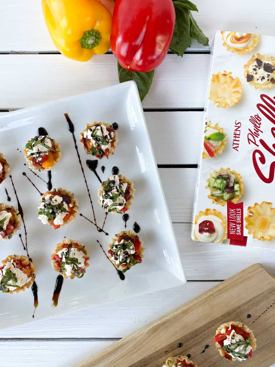 caprese phyllo cups with roasted peppers on a white plate.