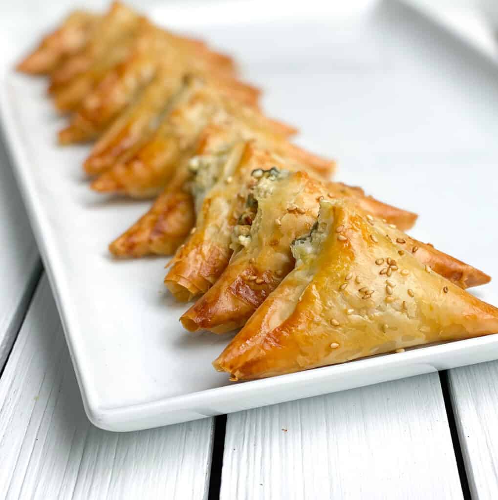 spinach and feta phyllo triangles on a white plate