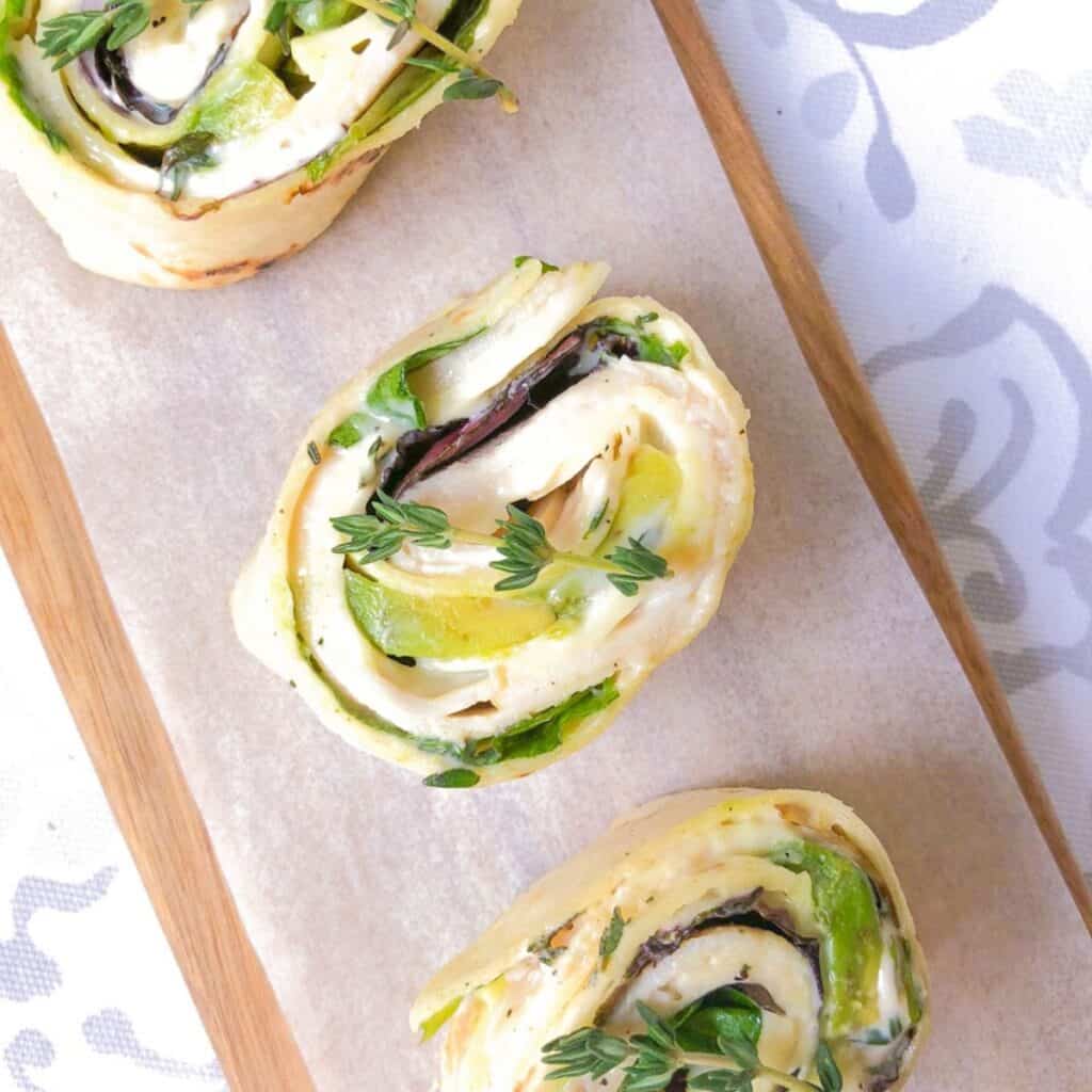 turkey and cheese pinwheels slices into rounds and displayed on a cutting board