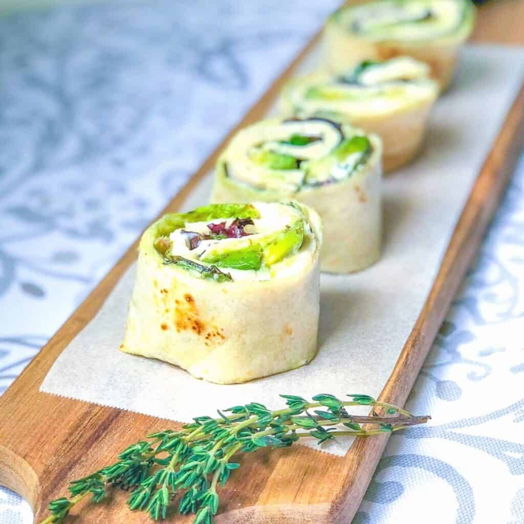 slices of turkey wrap laid out on a long cutting board with thyme